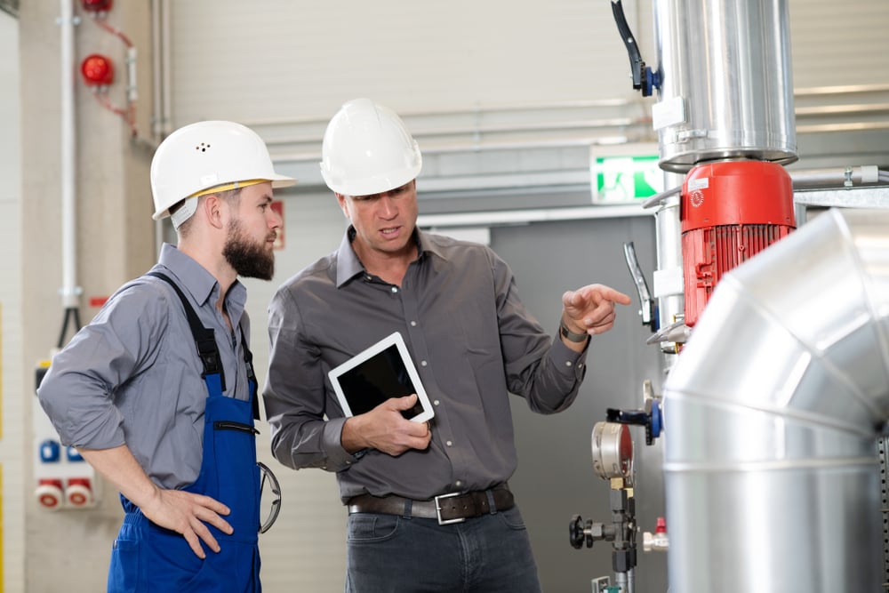 Boss,With,Worker,In,The,Background,In,His,Factory