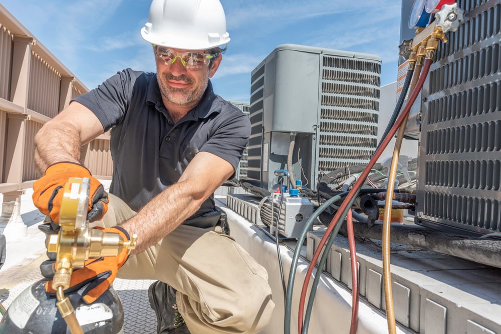 Hvac,Tech,Working,On,Installing,A,New,Air,Conditioner,Unit